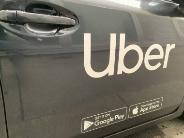 Viyana, Avusturya - 20 Ocak 2025: Ön yolcu kapısı ve bir Uber kullanıma hazır. Koyu renk araba boyasına kalın parlak harfler..