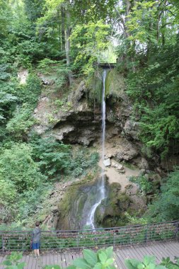 Miskolc, Macaristan-5 Ağustos 2024: Küçük çocuk Macaristan 'ın Bukk Milli Parkı' ndaki Lillafured kentindeki tarihi Palota Kalesi 'nin bahçelerinde Szinva deresinin destansı şelalesini hayrete düşürdü. Dikey