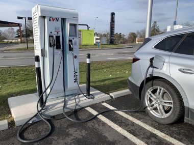 Ganserndorf, Aşağı Avusturya - 26 Ocak 2025: Güneşli bir günde şarj istasyonunda park halindeki elektrikli araba.