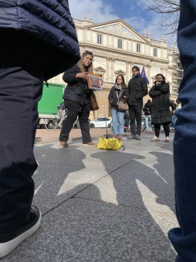 Milan, Lombardy, İtalya - 14 Şubat 2025: Şehir aylaklarının sarı şemsiyeli tur rehberi, turistlerin tarihi opera salonu 