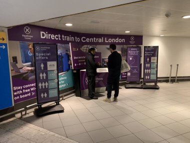 Londra, İngiltere, Birleşik Krallık - 25 Şubat 2025: Heathrow Express 'in Londra Heathrow havaalanında tipik mor renkli yardım ve bilgi masası.
