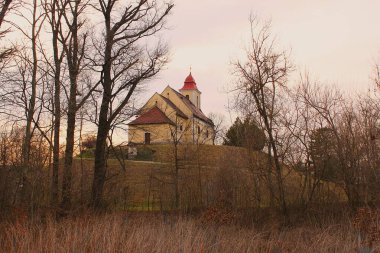 Kopfstetten, Gaenserndorf, Aşağı Avusturya - 08 Mart 2025: Saint Bartholomew Kilisesi düz Marchfeld 'de eski bir insan yapımı tepe üzerinde.