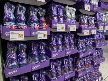 Lassee, Aşağı Avusturya, Avusturya - 08 Mart 2025: Avusturya 'daki bakkalda sergilenen ünlü mor ambalajlı Milka çikolatalı tavşanlarının zengin çeşitleri. Geleneksel Paskalya çikolataları.