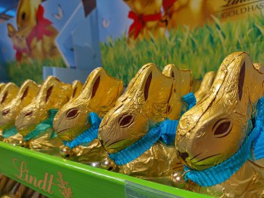 Lassee, Aşağı Avusturya, Avusturya - 08 Mart 2025 Lindt çikolatalı tavşanlarının tasmalı ve markette sergilenen küçük zilli ünlü altın paketlerinin ayrıntıları. Geleneksel Paskalya tatlıları.