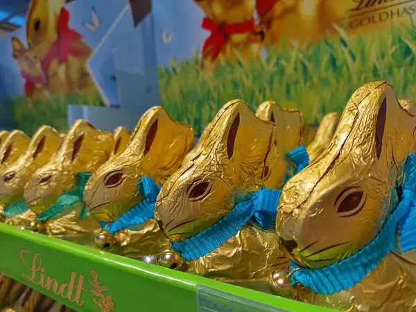 Lassee, Aşağı Avusturya, Avusturya - 08 Mart 2025 Lindt çikolatalı tavşanlarının tasmalı ve markette sergilenen küçük zilli ünlü altın paketlerinin ayrıntıları. Geleneksel Paskalya tatlıları.