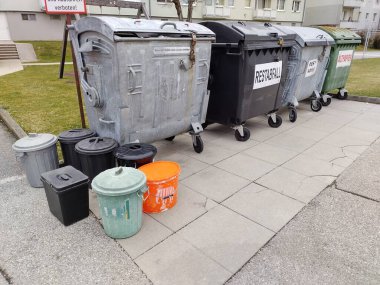 Freistadt, Avusturya - 11 Mart 2025: Avusturya 'da konut kompleksine ait atık toplama alanı. Konteynırlar asma kilitlerle korunuyor. Özel organik atık için daha küçük şekilli geri dönüşüm kutuları.