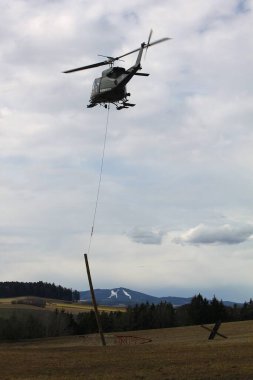 GUePl Geyerhof, St. Peter, Yukarı Avusturya - 12 Mart 2025: Avusturya Hava Kuvvetleri Agusta Bell AB-212, 5D-HO, Hafif Taşımacılık Helikopter Filosu, havada asılı duran ve yerden kaldıran kütükler.