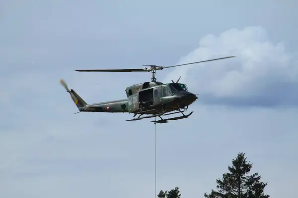 GUePl Geyerhof, St. Peter, Yukarı Avusturya - 12 Mart 2025: Avusturya Hava Kuvvetleri Agusta Bell AB-212, 5D-HO, Hafif Taşımacılık Helikopter Filosu, kanca operasyonu sırasında havada asılı kalır.
