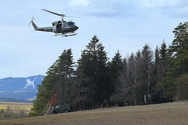 GUePl Geyerhof, St. Peter, Yukarı Avusturya - 12 Mart 2025: Avusturya Hava Kuvvetleri Agusta Bell AB-212, 5D-HO, Hafif Taşımacılık Helikopter Filosu, havada asılı duran ve metal yapısını yerden kaldıran.