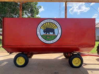 Plains, Georgia, ABD - 22 Eylül 2024: Buffalo Peanut Company, Plains Georgia 'nın logosu olan kırmızı traktör römorku. Hasat edilen fıstıkların nakliyesi. Tipik tarım Güney için iyidir..