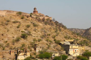 Amer, Rajasthan, Hindistan - 08 Mart 2019: Tepenin zirvesinde tipik bir kuleyle Amber Kalesi 'ni takip eden uzak duvarlara bakın.