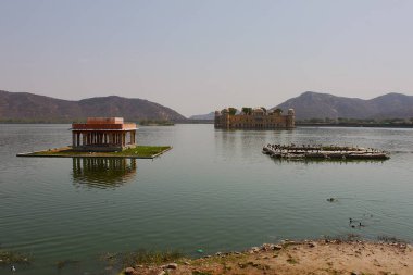 Jaipur, Rajasthan, Hindistan - 08 Mart 2019: Arkaplanda ünlü Su Sarayı Jal Mahal ve Aravalli tepeleriyle Man Sagar Gölü 'nün panoramik manzarası.