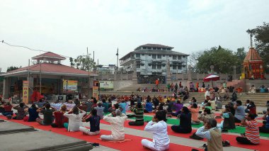 Varanasi, Uttar Pradesh, Hindistan - 14 Mart 2019: Yerel halk ve turistler bitmek bilmeyen aralıklarla Yoga çalışmak için sabahleyin Ghat 'ta toplandılar.