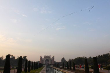Agra, Uttar Pradesh, Hindistan - 11 Mart 2019: Taj Mahal 'in ana kapısı (darwaza) veya V şeklinde uçan kuş sürüsüyle birlikte sarayın tacı.