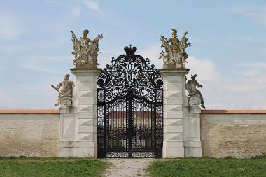 Marchegg, Gaenserndorf, Aşağı Avusturya - 5 Nisan 2025: Barok Şatosu Schloss Hof Savoy Prensi Eugene güzel heykeller tarafından çerçevelenmiş muhteşem demir arka kapıdan görüldü.