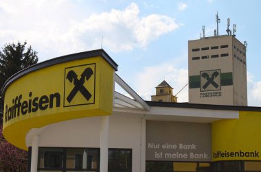 Angern an der March, Gaenserndorf, Aşağı Avusturya - Nisan 05, 2025: Raiffeisen 'in Gable çapraz logosu hem banka şubesi üzerinde hem de arka planda kooperatif harfler 