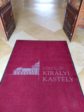 Godollo, Macaristan - 5 Ağustos 2024: Godollo Kraliyet Sarayı girişinde koyu kırmızı halı (Macarca: Godolloi Kiralyi Kastely), geniş açık çift kapılı. İmparatoriçe Sisi 'nin favori yazlık evi.