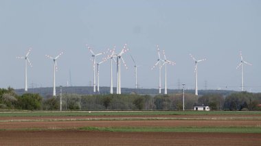 Weikendorf, Gaenserndorf, Aşağı Avusturya - 20 Nisan 2025: Tarlaları, demiryolu, rüzgar türbinleri ve yüksek voltajlı sütunları olan tarım arazisi.