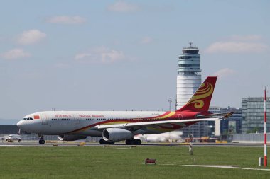 Schwechat, Aşağı Avusturya - 20 Nisan 2025: Hainan Arilines B-5955 Airbus A330-243 Viyana Uluslararası Havaalanı 16 numaralı pistten kalkıyor. Arka planda ayırt edici kule binası.