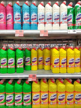 Sopron, Macaristan 9 Ağustos 2024: Sopron, Macaristan 9 Ağustos 2024: Bir süpermarkette sergilenen çok sayıda Domestos temizlik ve beyazlatıcı deterjan konteynırı. Dikey resim.