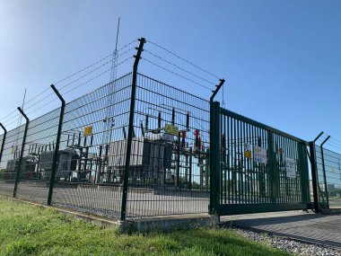 Baumgarten a der March, Gaenserndorf, Lower Austria - 22 Nisan 2025: Transformers ve çitin arkasındaki bir alt istasyonun devasa yıldırım iletkenleri ve birden fazla katman dikenli tel. Uzak dur.!