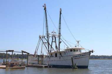 Bluffton, SC, ABD - 24 Eylül 2024: Babacığın Kızları adlı karides teknesi Güney Carolina 'nın Bluffton kentindeki May River' da demirledi. Güneşli yaz günü, mavi gökyüzü.