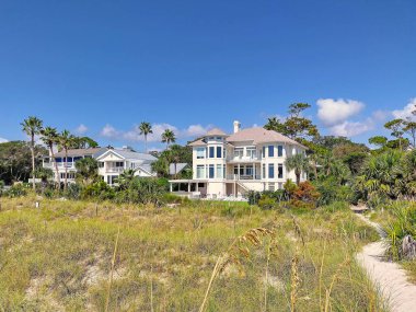 Hilton Head Adası, Güney Carolina, ABD - 24 Eylül 2024 Hilton Head Adası 'ndaki güzel sahil evleri. Güneşli bir gün. Coligny Beach Parkı yakınlarındaki sakin manzara. Çimenler, kum tepeleri ve ağaçlarla çevrili.