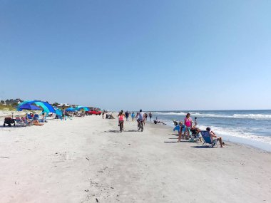 Hilton Head Adası, Güney Carolina, ABD - 24 Eylül 2024 Coligny Beach Park 'ta güzel bir gün. İnsanlar güneşten zevk alır, çadır kurar, sandalyede güneşlenir, kumda bisiklet sürerler.. 