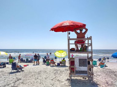 Hilton Head Adası, Güney Carolina, ABD - 24 Eylül 2024 Coligny Beach Parkı 'nda cankurtaran kulesinden kalabalık okyanus manzaralı cankurtaran. İnsanlar kumsalda güneşli güzel bir günün tadını çıkarıyor.