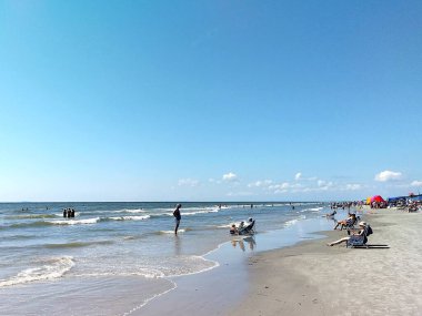 Hilton Head Adası, SC, ABD - 24 Eylül 2024: Coligny Beach Park, Hilton Head Adası, Güney Carolina 'da güzel güneşli bir gün. İnsanlar sahilde sandalyede güneşleniyorlar..   