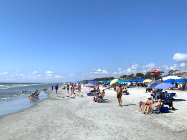 Hilton Head Adası, SC, ABD - 24 Eylül 2024 Güney Carolina 'daki Hilton Head Adası' ndaki Coligny Beach Park 'ta güneşli güzel bir gün. İnsanlar deniz kıyısında kıyı yaşamını seviyorlar. Güneş banyosu, dinlenme.