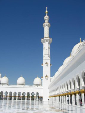 Abu Dabi, Birleşik Arap Emirlikleri - 24 Mayıs 2017 Şeyh Zayed Büyük Camii 'nin etkileyici avlusuna bakın. Mavi gökyüzü beyaz mermer ve altın dekorasyonla çelişiyor. Dikey.