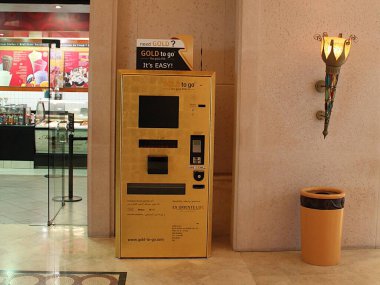 Dubai, Birleşik Arap Emirlikleri - Ekim 02, 2012: Dubai 'deki alışveriş merkezinde altın sikke ve bar makinesi. Gold to Go tarafından işletilen bir makineden kredi kartıyla ya da nakitle altın alın.