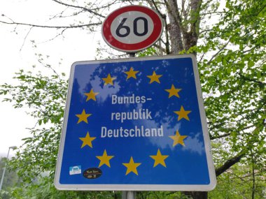 Wildbichl, Tyrol, Avusturya - 4 Mayıs 2025: Almanya ulusal sınırı. İşaretler Almanya Federal Cumhuriyeti 'ne giriş olduğunu gösteriyor. Avrupa Birliği yıldız çemberi. Hız sınırı levhası. Göç kavramı