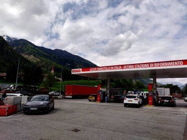 Freienfeld, Bolzano, Güney Tyrol, İtalya 4 Mayıs 2025: İtalya-Avusturya sınırındaki yoğun Esso benzin istasyonu. Brenner Geçidi 'nden önceki son benzin istasyonu. Doğu Alp dağlarının en önemli geçitlerinden biri..