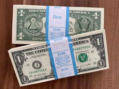 Viyana, Avusturya - 14 Mayıs 2025: Gıcır gıcır ABD Doları banknotları veya ABD Doları banknotları. BEP gravür ve baskı bürosu tarafından yeni üretildi. Ahşap arka planda $.