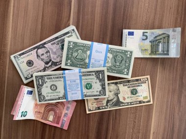 Viyana, Avusturya - 14 Mayıs 2025: Gıcır gıcır 1 ABD Doları banknotlarının yanı sıra gevşek 5, 10 ABD Doları ve Euro banknotları. BEP gravür ve baskı bürosu tarafından yeni üretildi. - Evet. .