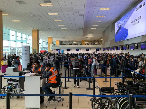 Callao, Lima, Peru - 25 Mayıs 2025: Yoğun bir sabahta Jorge Chvez Uluslararası Havalimanı SPJC 'nin kalkış salonunda bavullarını kontrol etmek için kuyruğa giren yolcular.