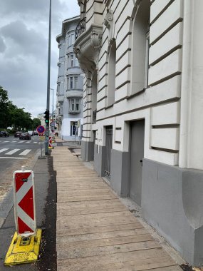 Viyana, Avusturya - 10 Temmuz 2025: Kazı alanı ahşap kalaslarla kaplı ve kırmızı beyaz trafik rehberi feneriyle korunuyor. Kaldırımda yayalar için kısıtlamalar var. Dikey.