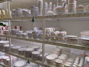 Gmunden, Avusturya 24 Ağustos 2025: Gmundner Keramik (seramik) mağazasının içi. 500 yıl boyunca yanan desenli eşsiz çömlekçilik sofra takımları yapmak. Kase, kap ve tabakla dolu raflar.