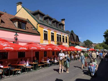 Viyana, Avusturya - 24 Ağustos 2025: Ziyaretçiler her yıl düzenlenen Viyana şarap imalat festivali Neustifter Kirtag 'in renkli galeri stantları ve pazar tribünlerinde gezinmekten keyif alıyorlar.