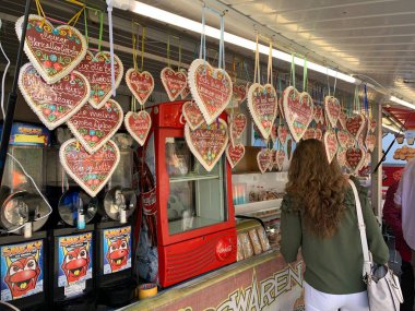 Viyana, Avusturya - 24 Ağustos 2025: Kadınlar, süslenmiş zencefilli ekmek kalplerinin dondurucu aşk metinleriyle süslendiği şekerleme standında seçimini yapıyor. Aşk ve tatlıya düşkünlük.