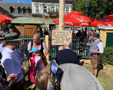 Viyana, Avusturya - 24 Ağustos 2025: Geleneksel Viyana şarap üreticisi festivali Neustifter Kirtag sırasında ziyaretçiler sembolik Hiatabaum 'a (koruyucu ağaç) bir çivi çaktılar. Son çekiç darbesi kaybeder.