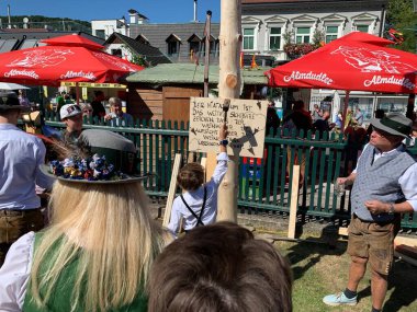 Viyana, Avusturya - 24 Ağustos 2025: Geleneksel Viyana şarap üreticisi festivali Neustifter Kirtag sırasında ziyaretçiler sembolik Hiatabaum 'a (koruyucu ağaç) bir çivi çaktılar. Son çekiç darbesi kaybeder.