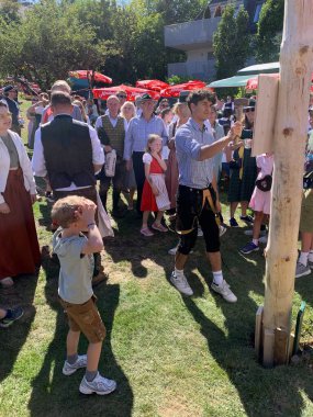 Viyana, Avusturya - 24 Ağustos 2025: Geleneksel Viyana şarap üreticisi festivali Neustifter Kirtag sırasında ziyaretçiler sembolik Hiatabaum 'a (koruyucu ağaç) bir çivi çaktılar. Son çekiç darbesi kaybeder.
