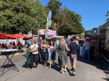 Viyana, Avusturya - 24 Ağustos 2025: Ziyaretçiler her yıl düzenlenen Viyana şarap imalat festivali Neustifter Kirtag 'in renkli galeri stantları ve pazar tribünlerinde gezinmekten keyif alıyorlar.