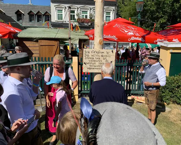 Viyana, Avusturya - 24 Ağustos 2025: Geleneksel Viyana şarap üreticisi festivali Neustifter Kirtag sırasında ziyaretçiler sembolik Hiatabaum 'a (koruyucu ağaç) bir çivi çaktılar. Son çekiç darbesi kaybeder.