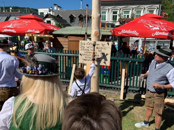 Viyana, Avusturya - 24 Ağustos 2025: Geleneksel Viyana şarap üreticisi festivali Neustifter Kirtag sırasında ziyaretçiler sembolik Hiatabaum 'a (koruyucu ağaç) bir çivi çaktılar. Son çekiç darbesi kaybeder.