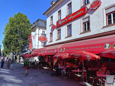 Bad Reichenhall, Germany - September 20, 2025: View of traditional Caf Reber with shaded terrace in busy pedestrian zone of Bavarian town. Famous for its homemade Mozart Chocolates. Sunny summer day