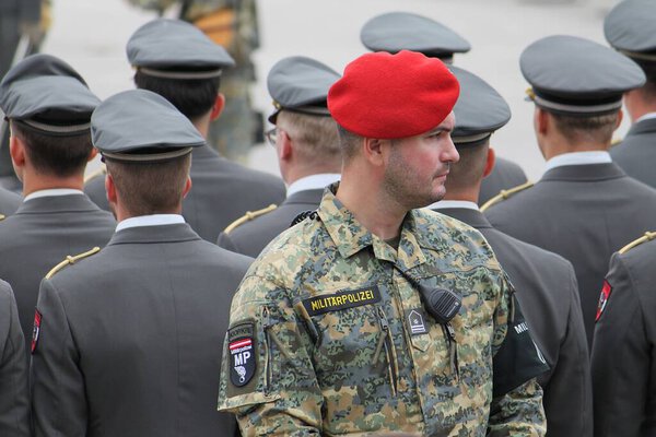 Wiener Neustadt, Lower Austria - September 27, 2025: Austrian military policeman in six colour camouflage pattern uniform and red beret securing an event at Theresian Military Academy.